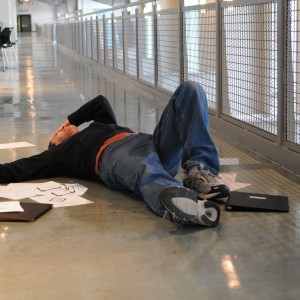 An image of a distressed man with papers around him while he is on the floor after a slip and fall.